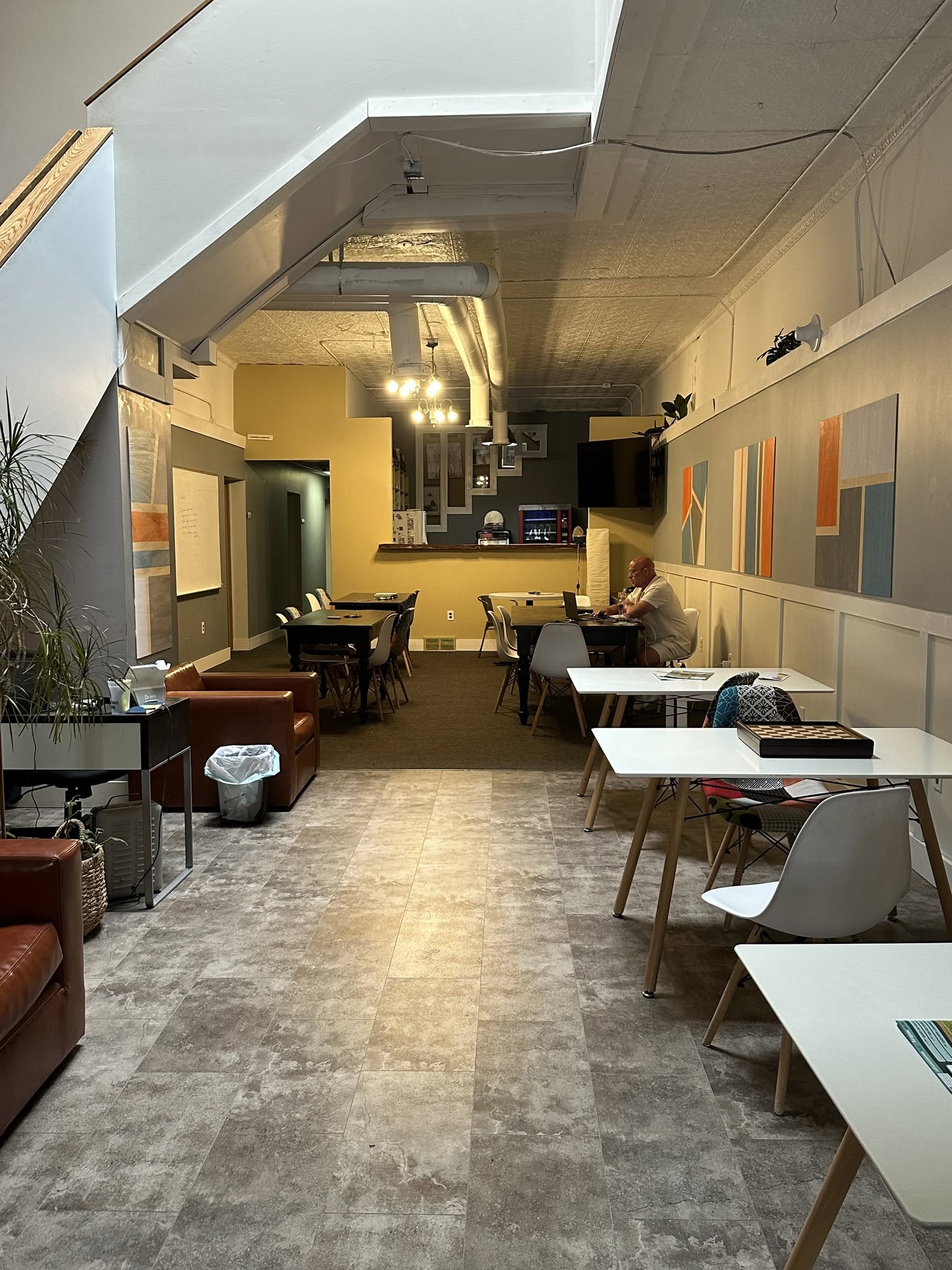 Open co-working space with shared desks and colorful wall art